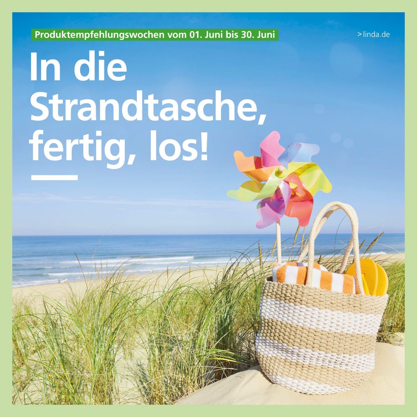 Strandtasche mit buntem Windrad und Handtüchern vor einem Strandszenario.